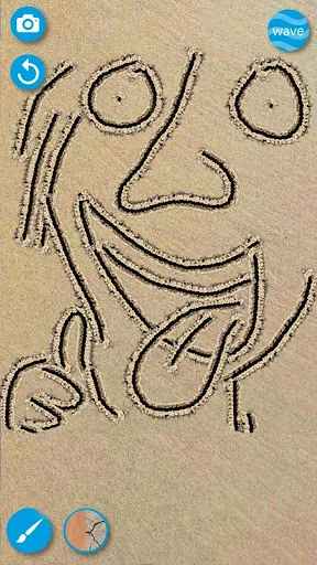 Simple smiling face character sketch drawn in sand demonstrating the doodle and drawing app capabilities